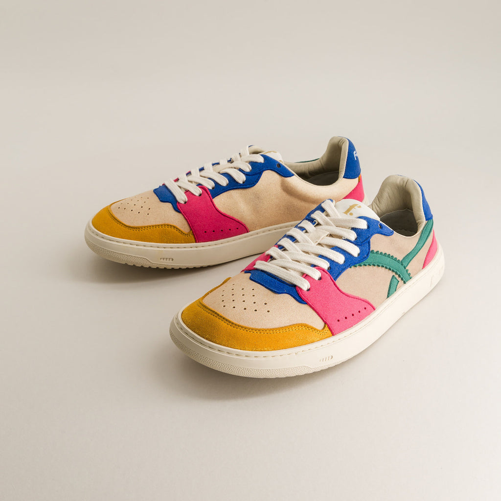 Colorful sneakers with a beige, blue, pink, and yellow design on a light gray background