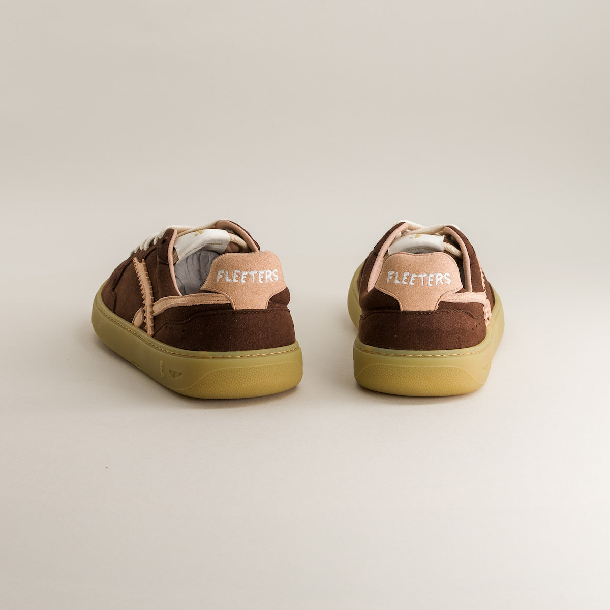 Pair of brown and beige sneakers with 'Fleeters' branding on a light gray background