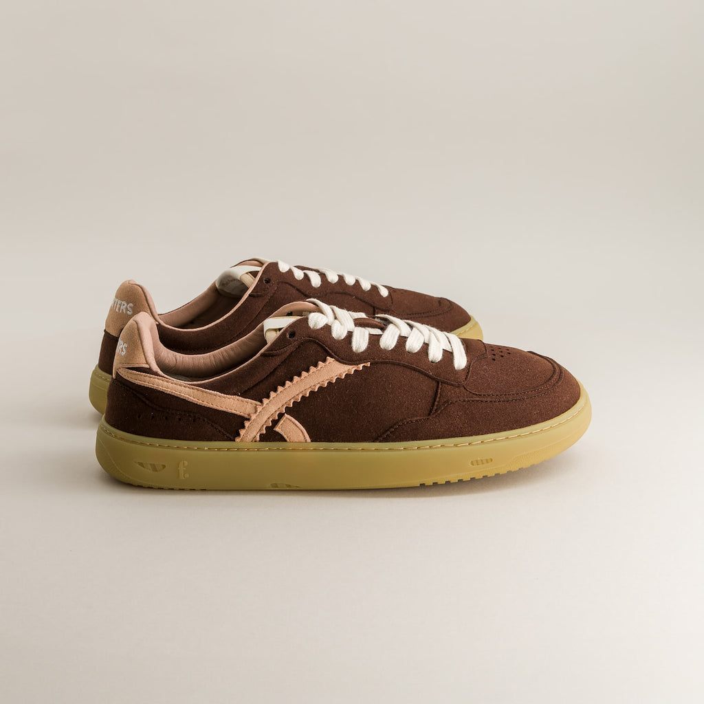 Brown minimalist sneakers with beige soles on a light gray background