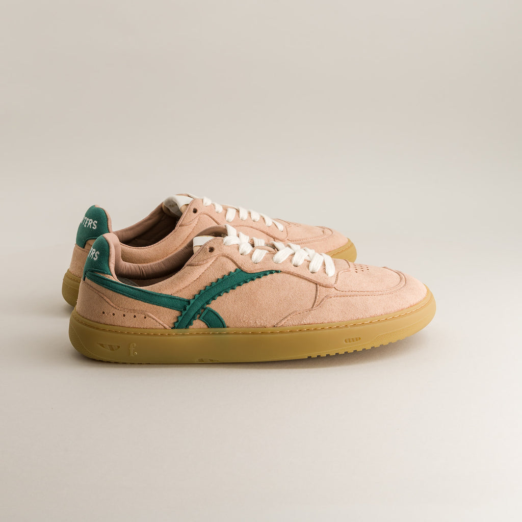 Pair of pink barefoot sneakers with green accents on a light gray background