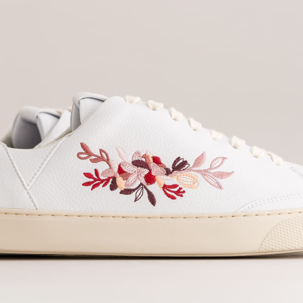 White barefoot sneakers with floral impression on the side.