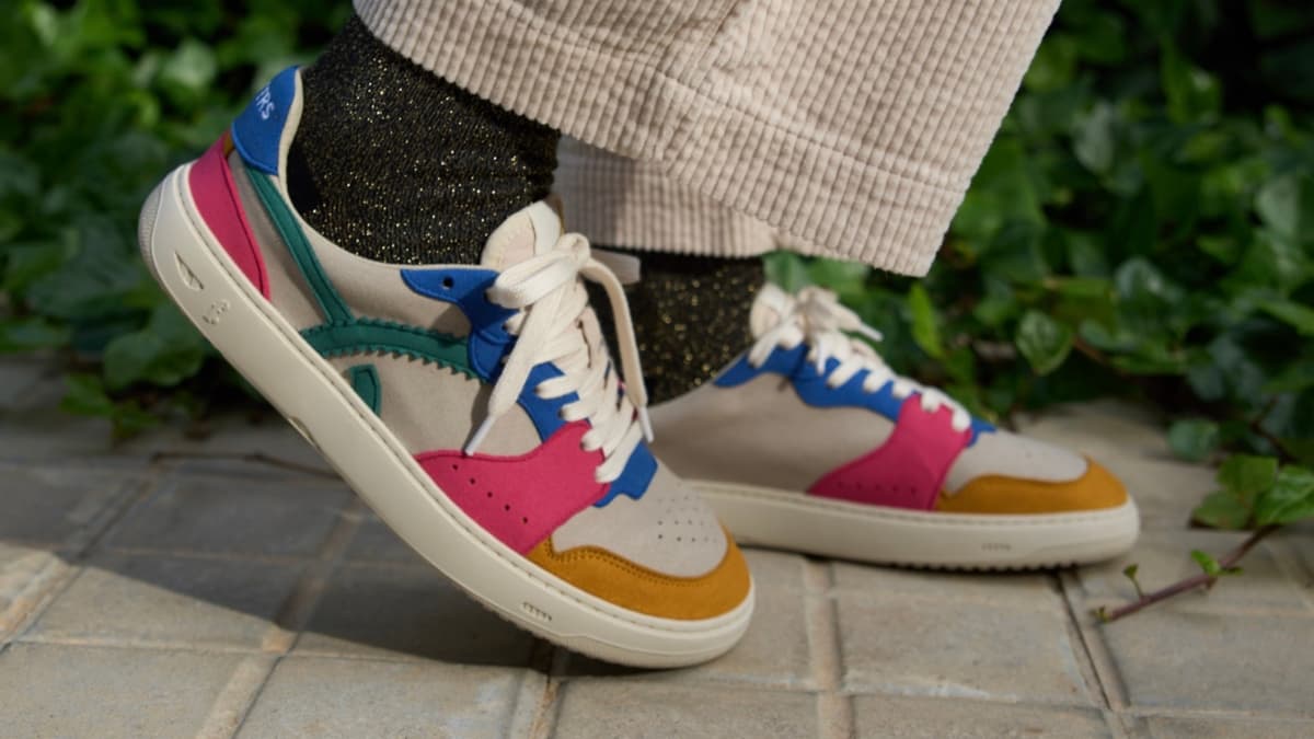 Colorful barefoot sneakers worn on a person's feet with a blurred background