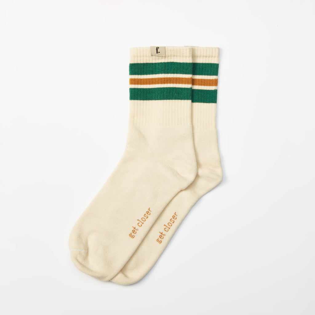 A pair of cream-colored barefoot socks with green and brown stripes near the cuff, featuring the words 'get closer' printed in brown on the soles, displayed on a clean white background.