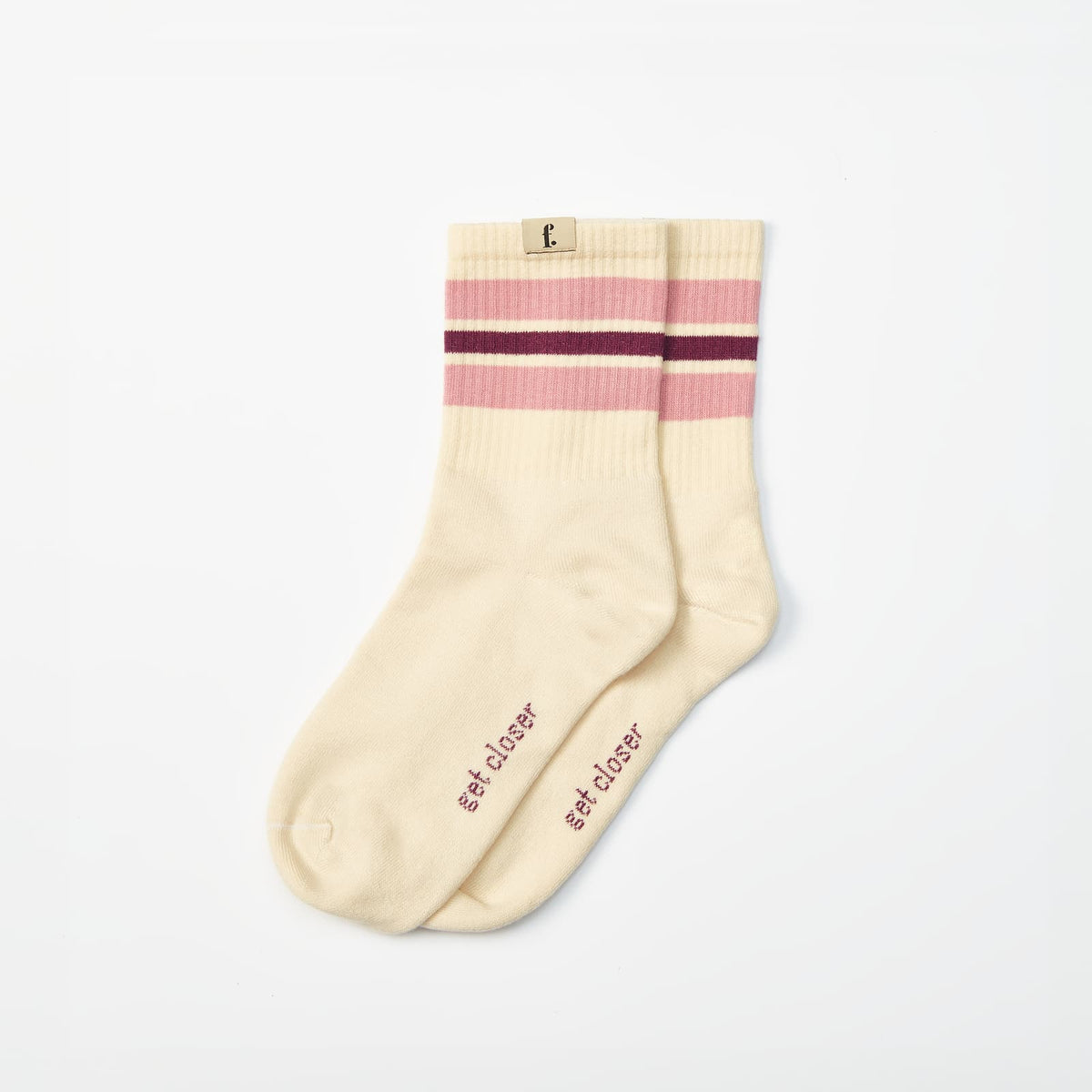 A pair of cream-colored barefoot socks with pink and burgundy stripes near the ribbed cuff, featuring the text 'get closer' printed on the sole, displayed on a clean white background.