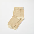 A pair of light beige barefoot socks with a contrasting cream toe and heel, laid flat on a clean white background. 