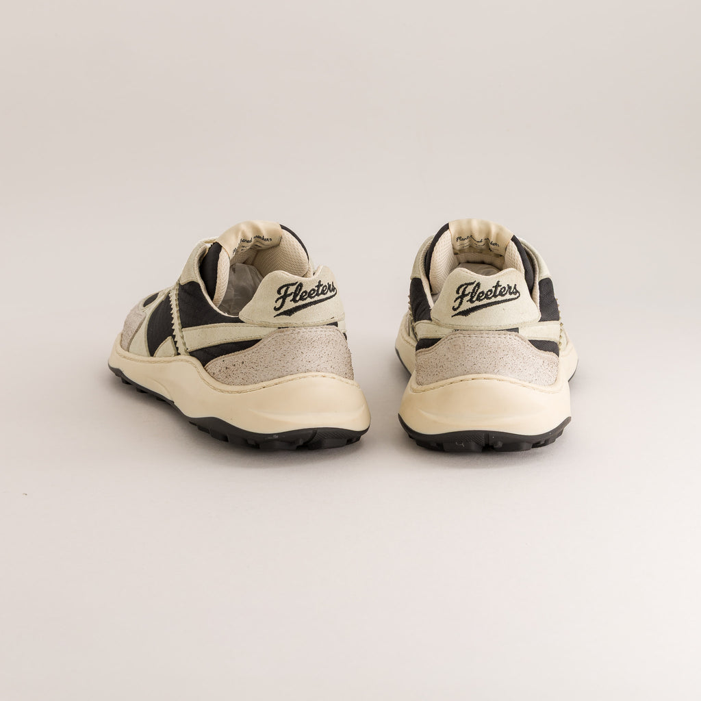 A pair of vintage barefoot sneakers shown from the back, featuring cream-colored leather and textured gray suede panels with black accents and soles.