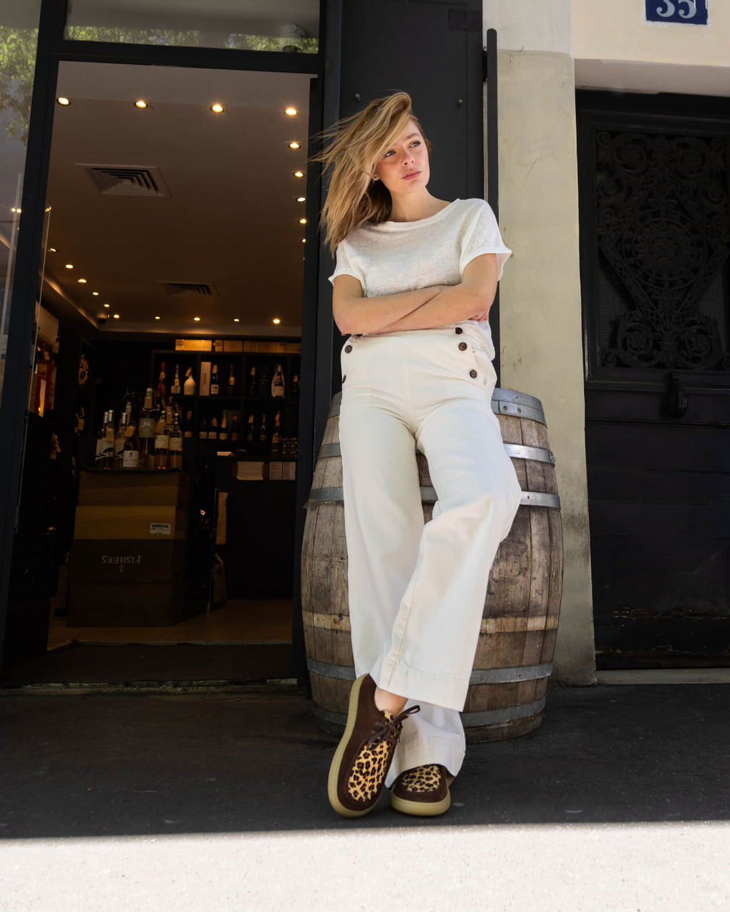 Woman with leopard barefoot derbies in front of a wine shop